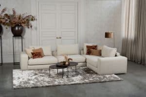 Beige bank met verschillende elementen en een sfeervolle rood / roze interieurstyling.
