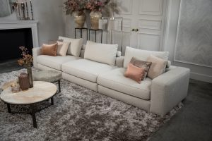 Beige bank met verschillende elementen en een sfeervolle rood / roze interieurstyling.