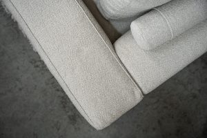 Beige bank met verschillende elementen en een sfeervolle rood / roze interieurstyling.